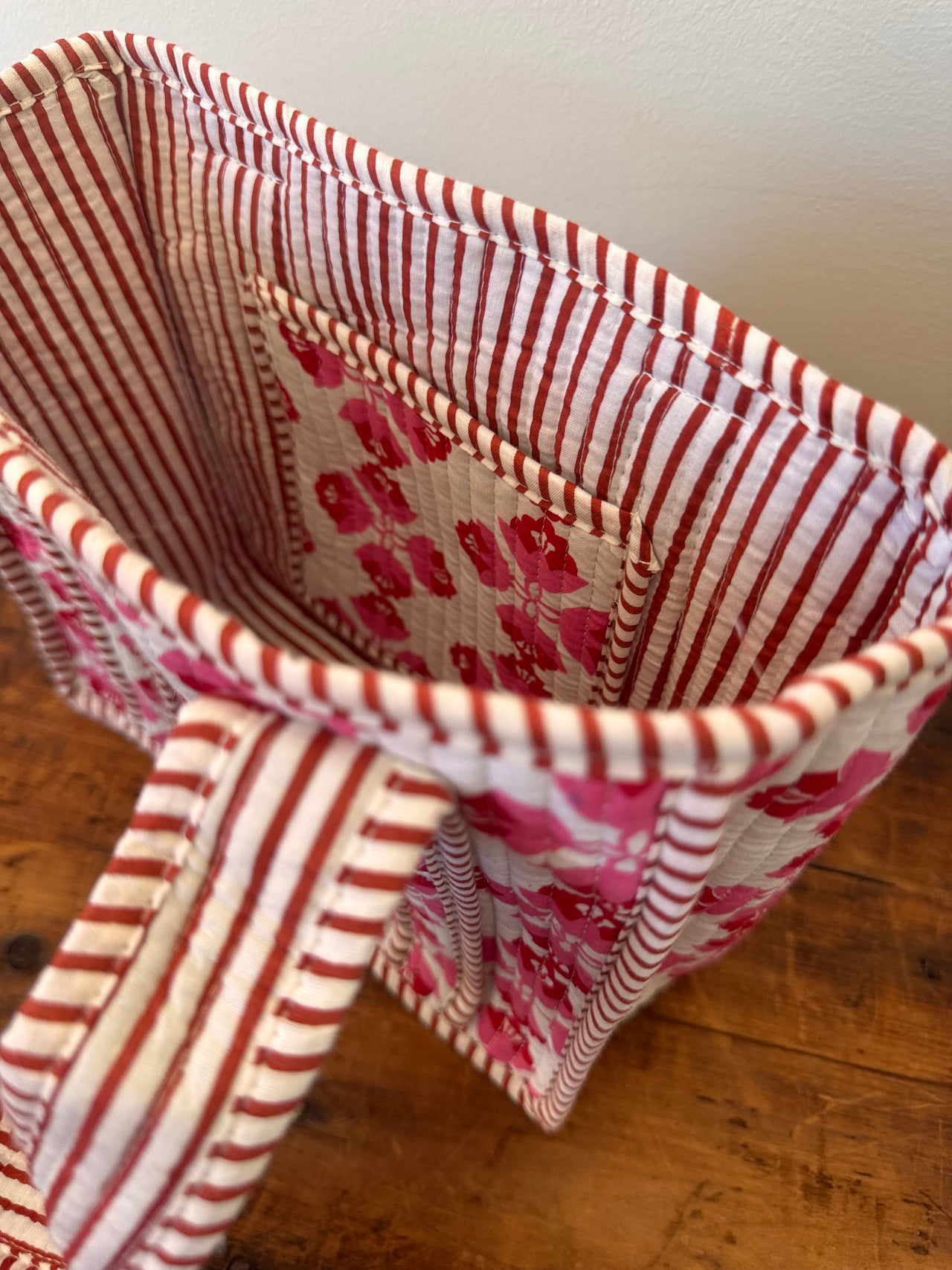 Fabric basket with red and white striped pattern on a wooden surface