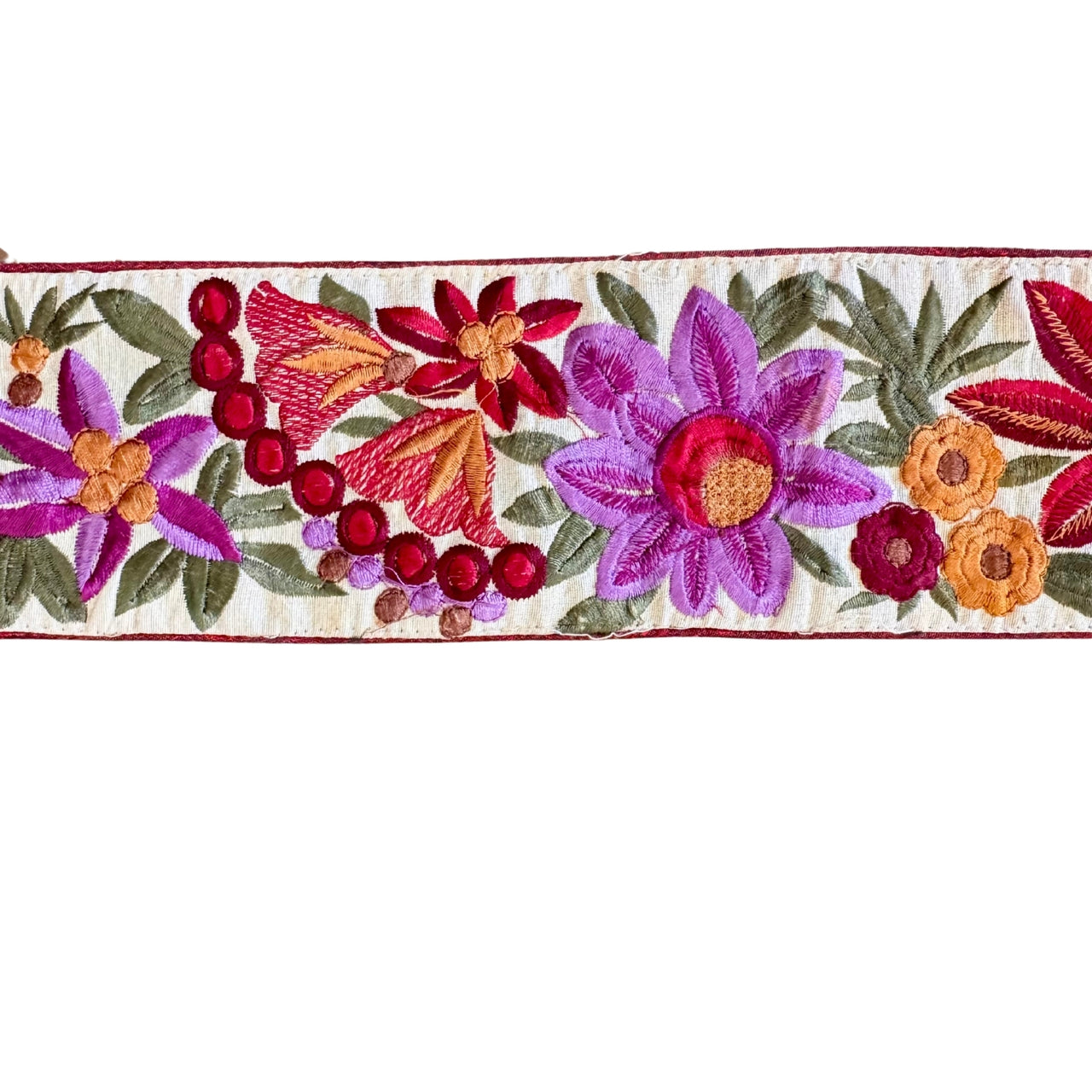 Embroidered floral design with colorful flowers and leaves on a white background