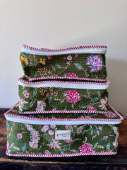 Set of three floral-patterned storage boxes stacked on a wooden surface with a neutral background.