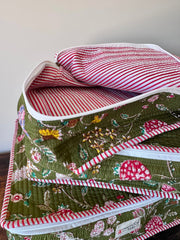 Floral-patterned fabric with red and white striped lining on a plain background