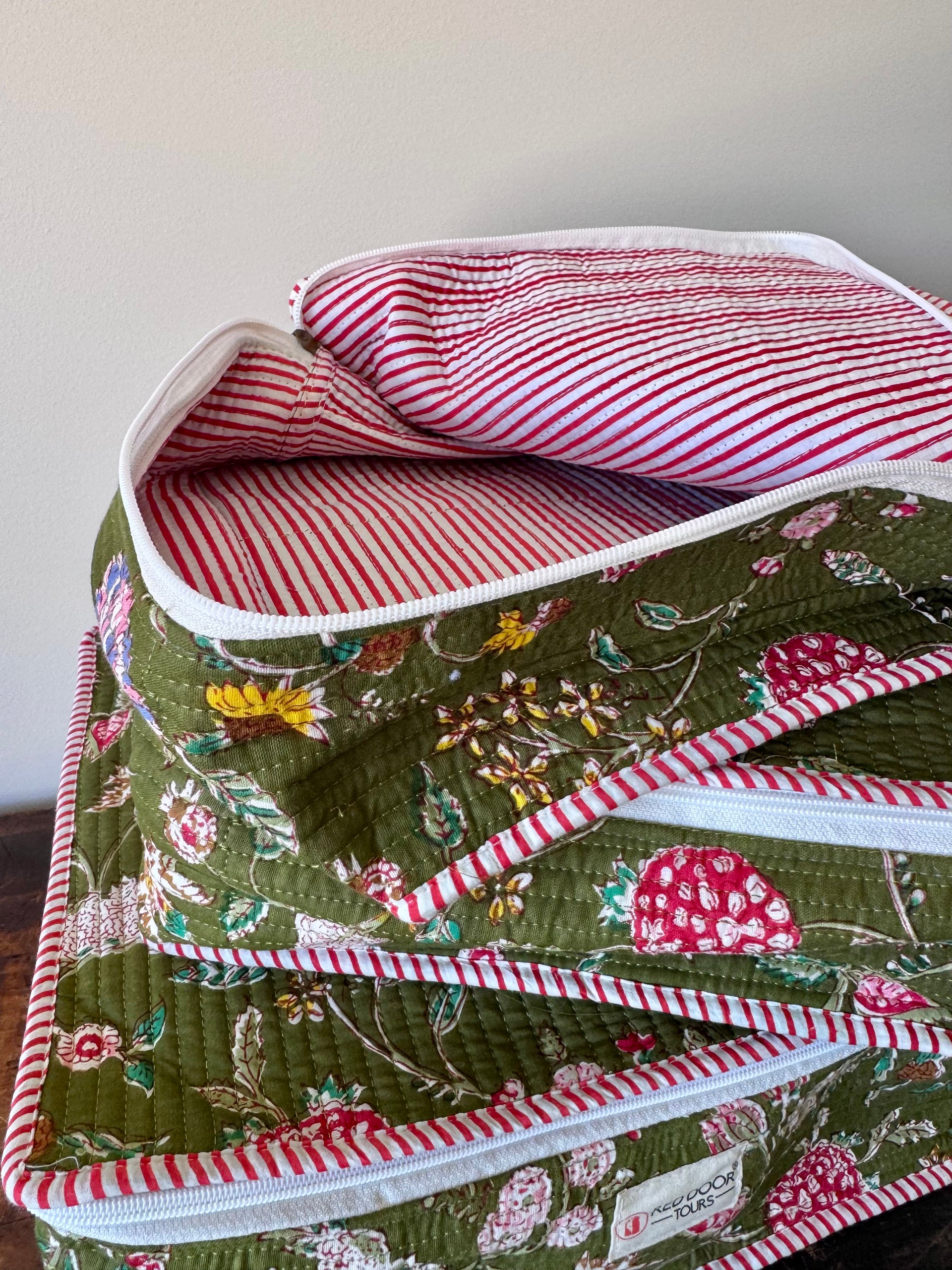 Floral-patterned fabric with red and white striped lining on a plain background