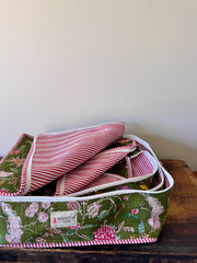 Set of fabric storage bins with floral and striped patterns on a wooden surface.