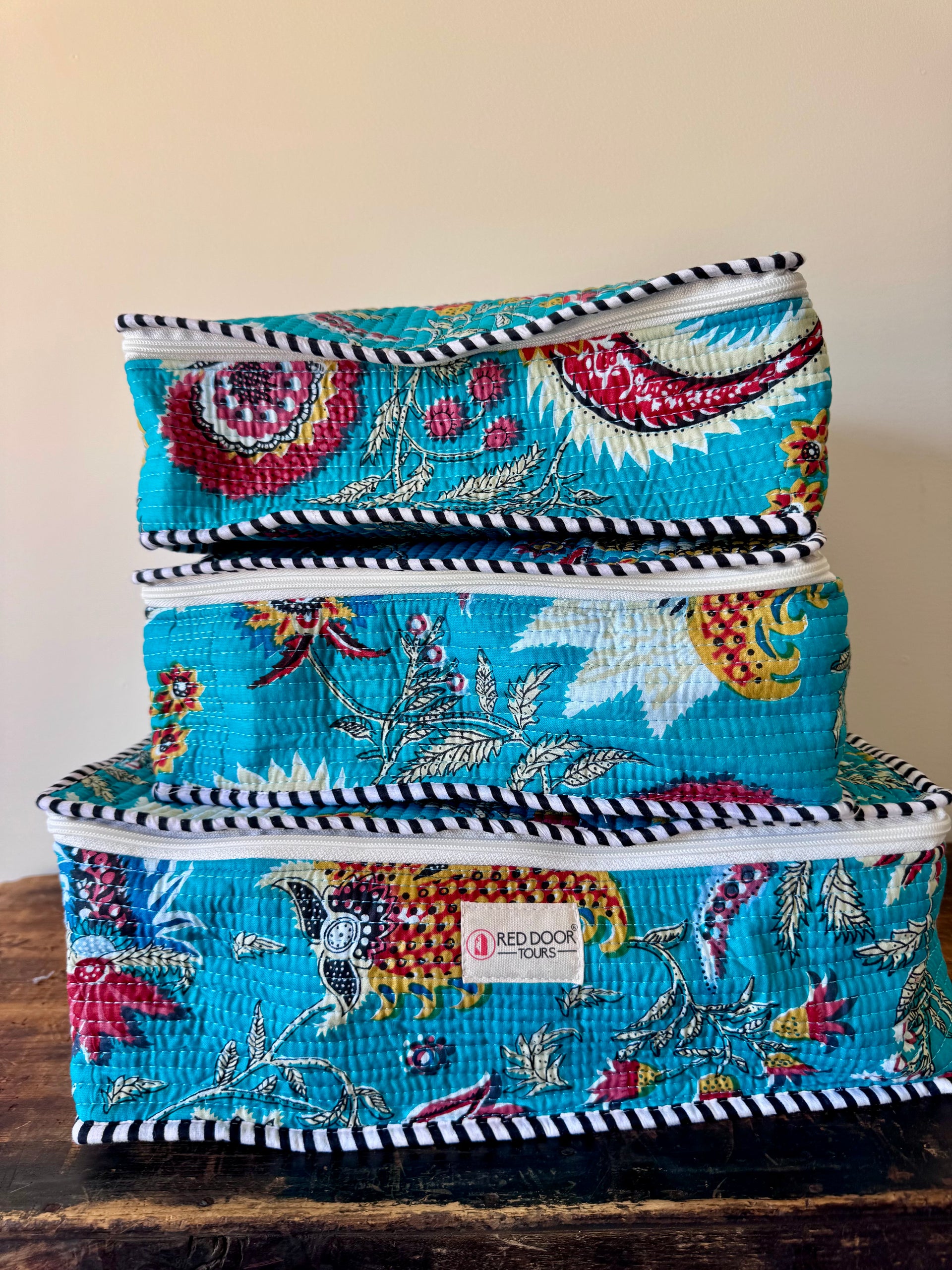 Set of three colorful fabric storage boxes stacked on a wooden surface.