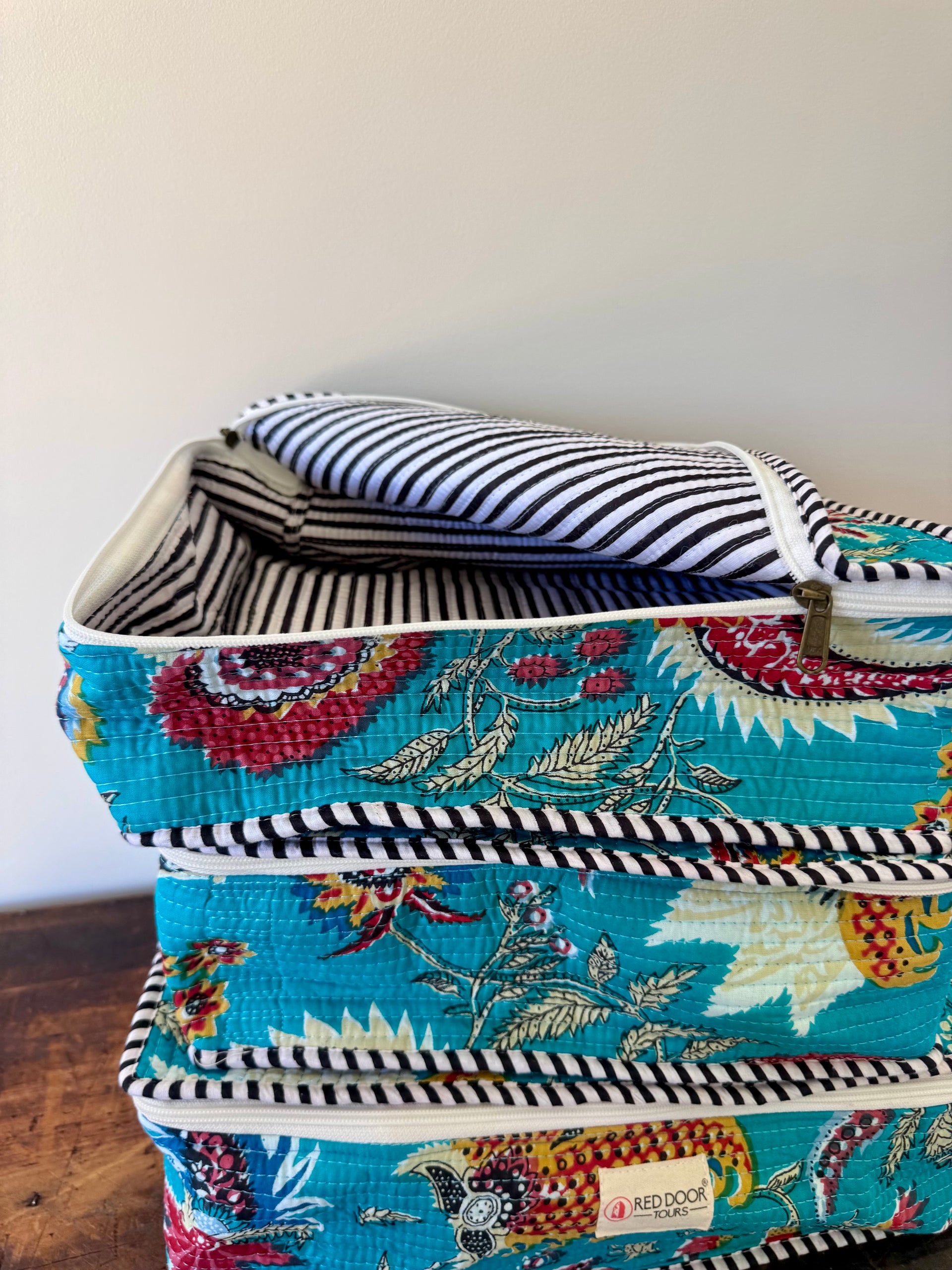 Stack of fabric storage bins with floral design on a wooden surface