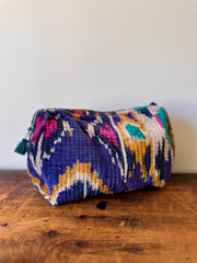 Colorful patterned pouch on a wooden surface with a white background