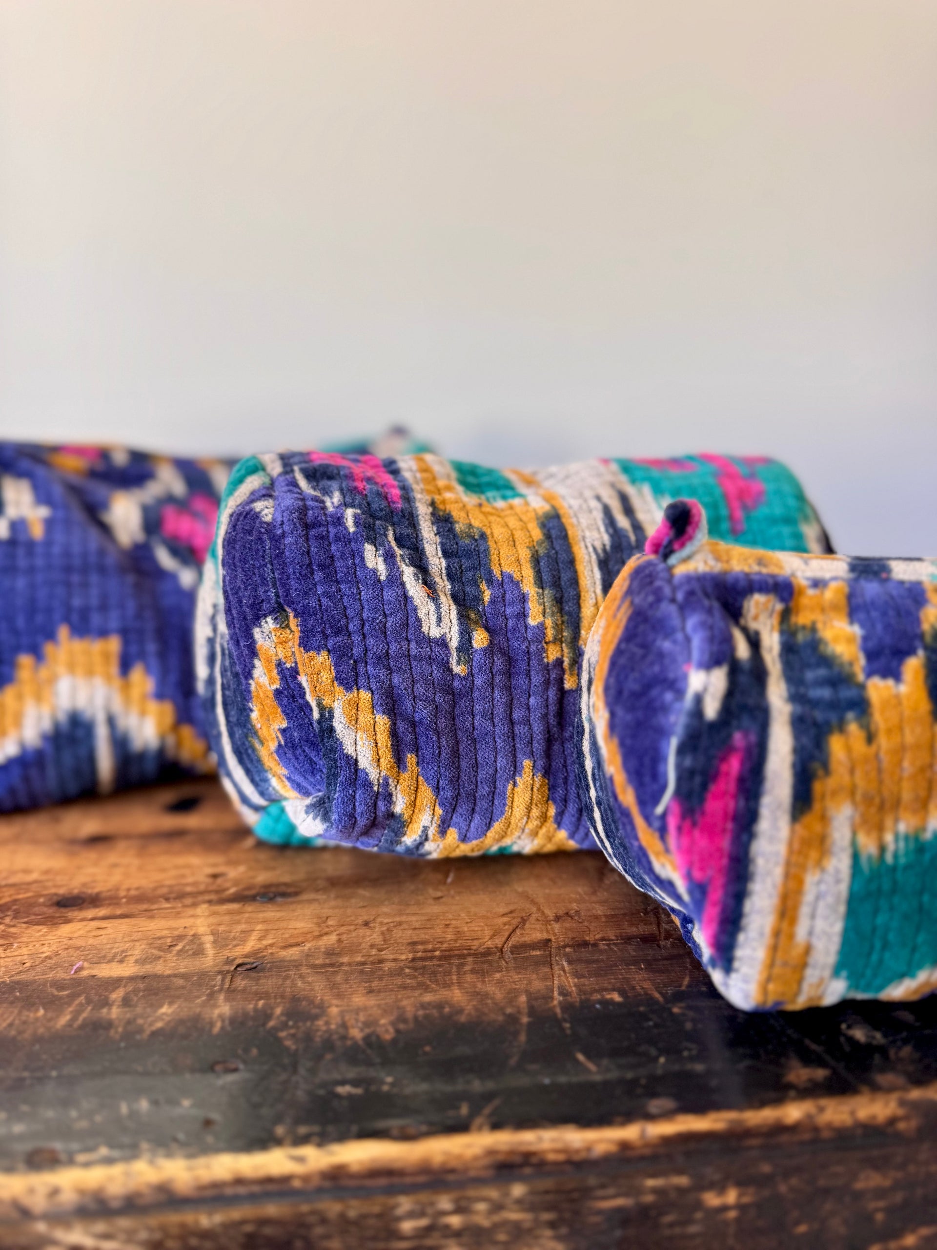Colorful patterned fabric roll on a wooden surface with a white background