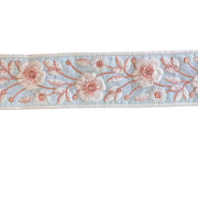 Floral embroidery ribbon with pink flowers on a light blue background