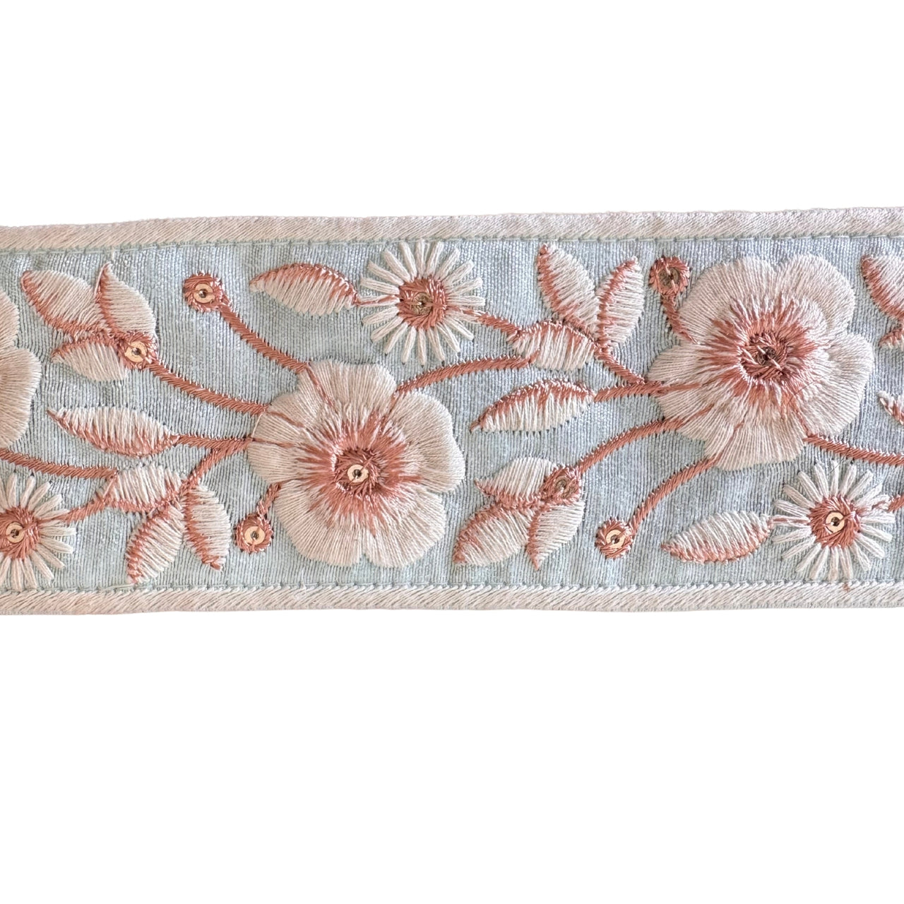 Embroidered floral ribbon with pink flowers on a light blue background