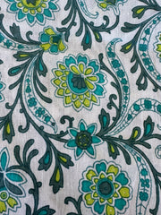 Close-up of a fabric with a floral paisley pattern in green, blue, and black on a white background.